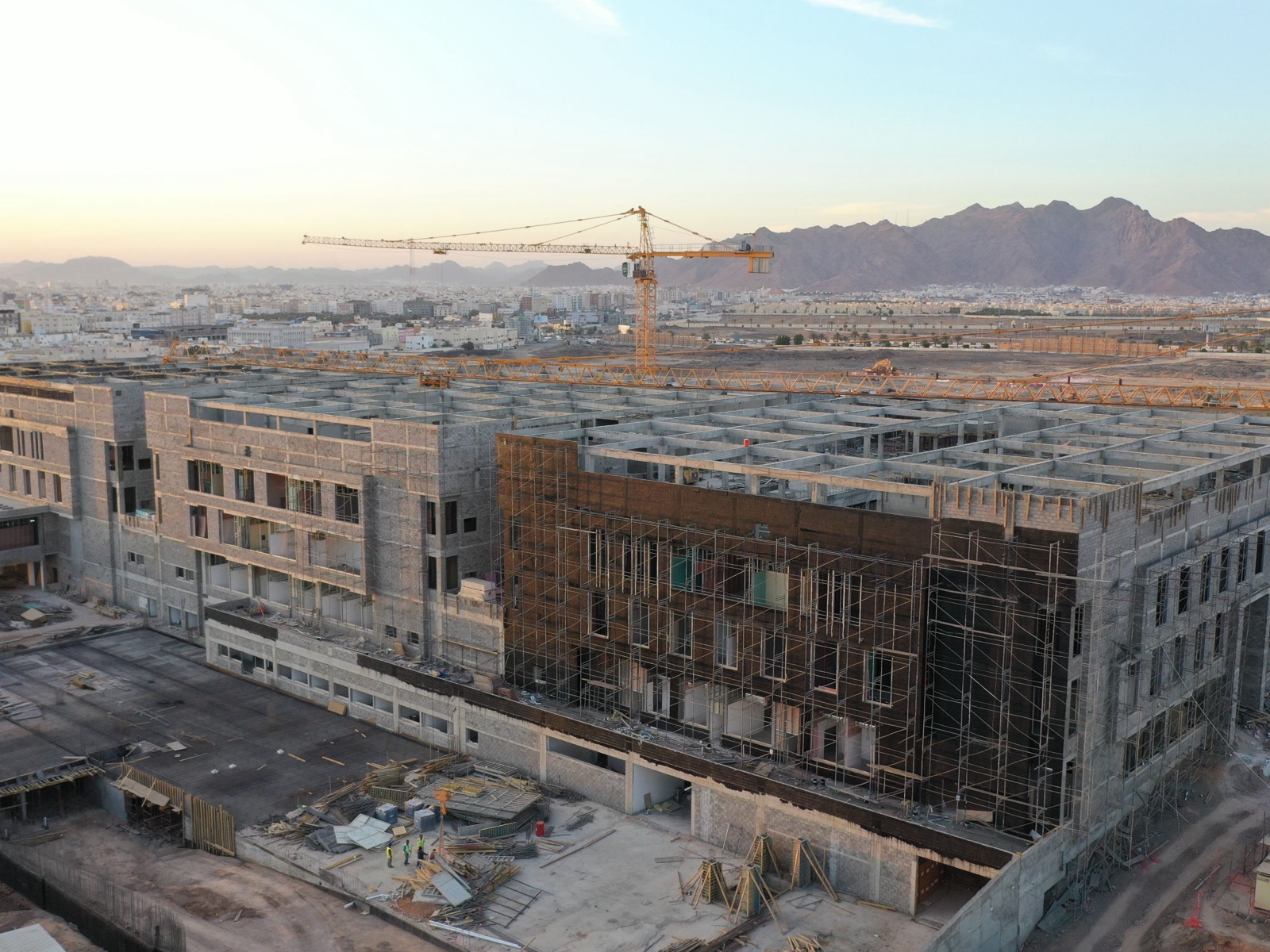 Multi-story commercial building under construction with workers and scaffolding